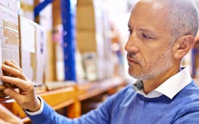 Warehouse manager checking a shipping label against a handheld device during ERP integration testing