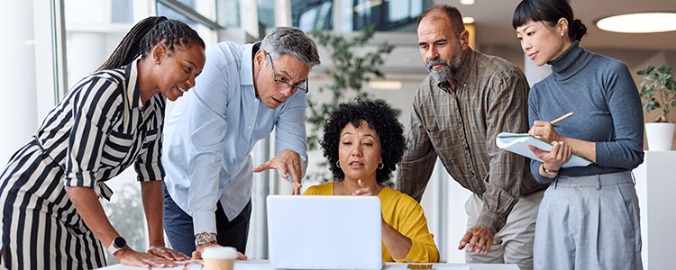 Team of executives reviewing a build vs buy AI strategy for ERP on a laptop