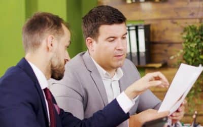 Two executives reviewing ERP cost estimates at an office desk