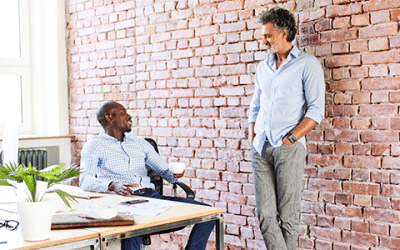 Dos ejecutivos conversan en una oficina sobre la estructura de revendedor vs. proveedor de ERP