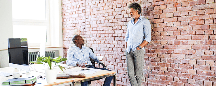 Dos ejecutivos conversan en una oficina sobre la estructura de revendedor vs. proveedor de ERP
